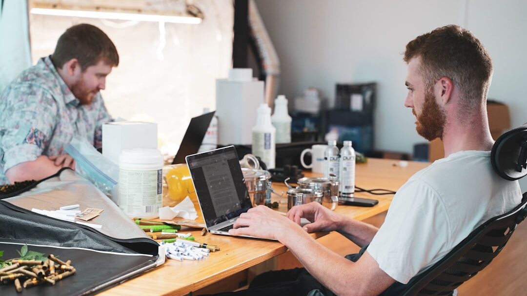 Group of people working together at a conference table with laptops
