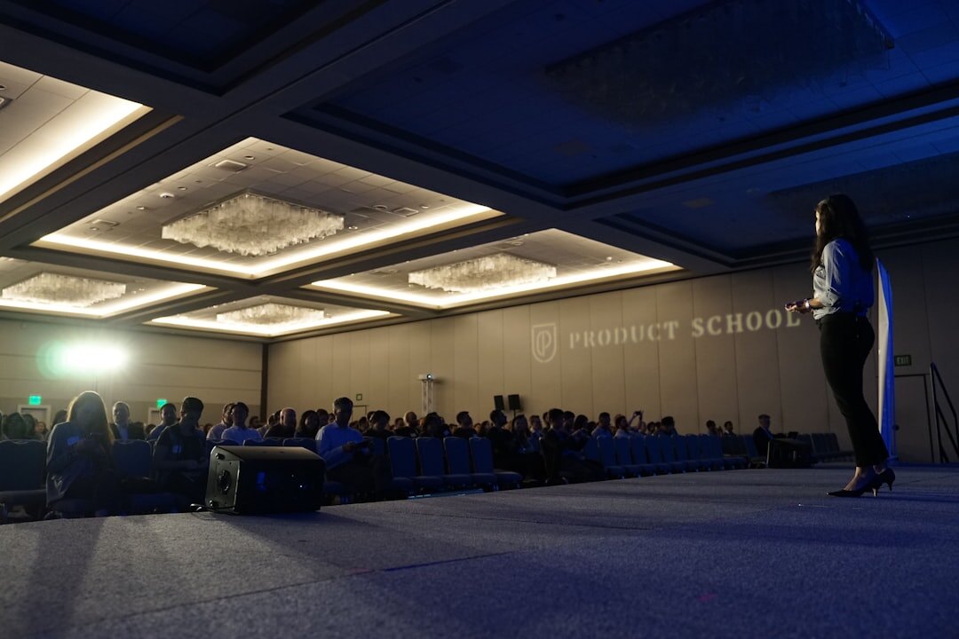 Conference keynote speaker presenting on stage to a large audience